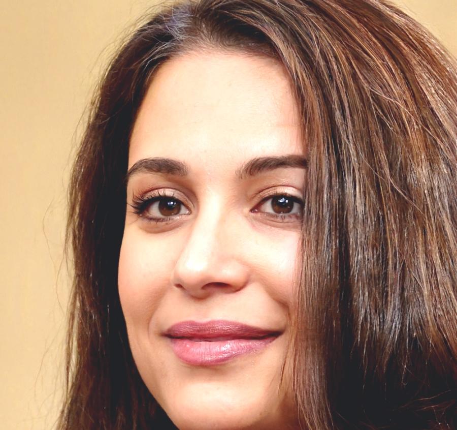 Professional film editor Maya Chen working at her editing station with multiple monitors